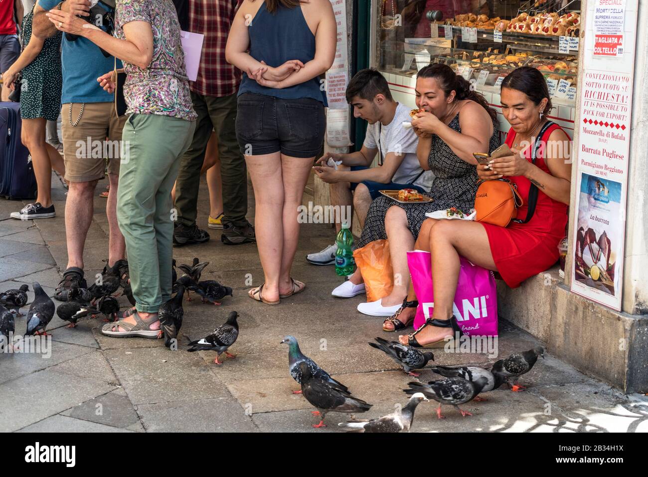 Tourist eating take away,fast foods on the streets of Venice, Italy Stock Photo