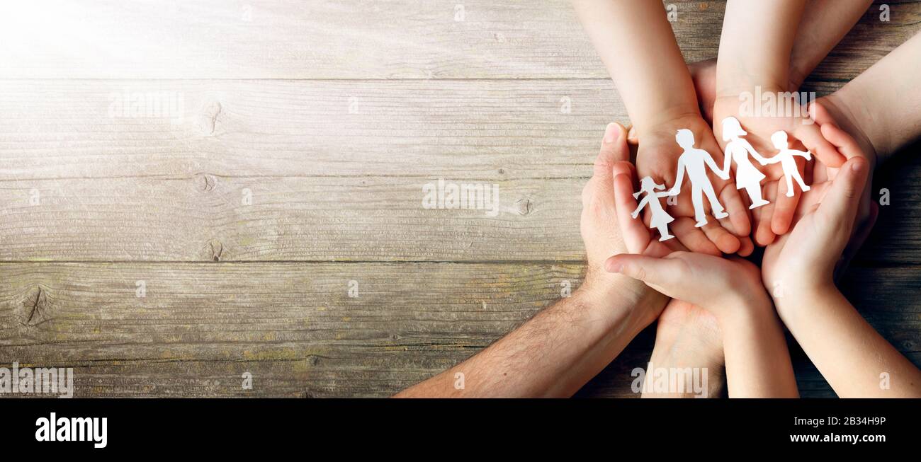 Family Care Concept Hands With Paper Silhouette On Table Stock Photo