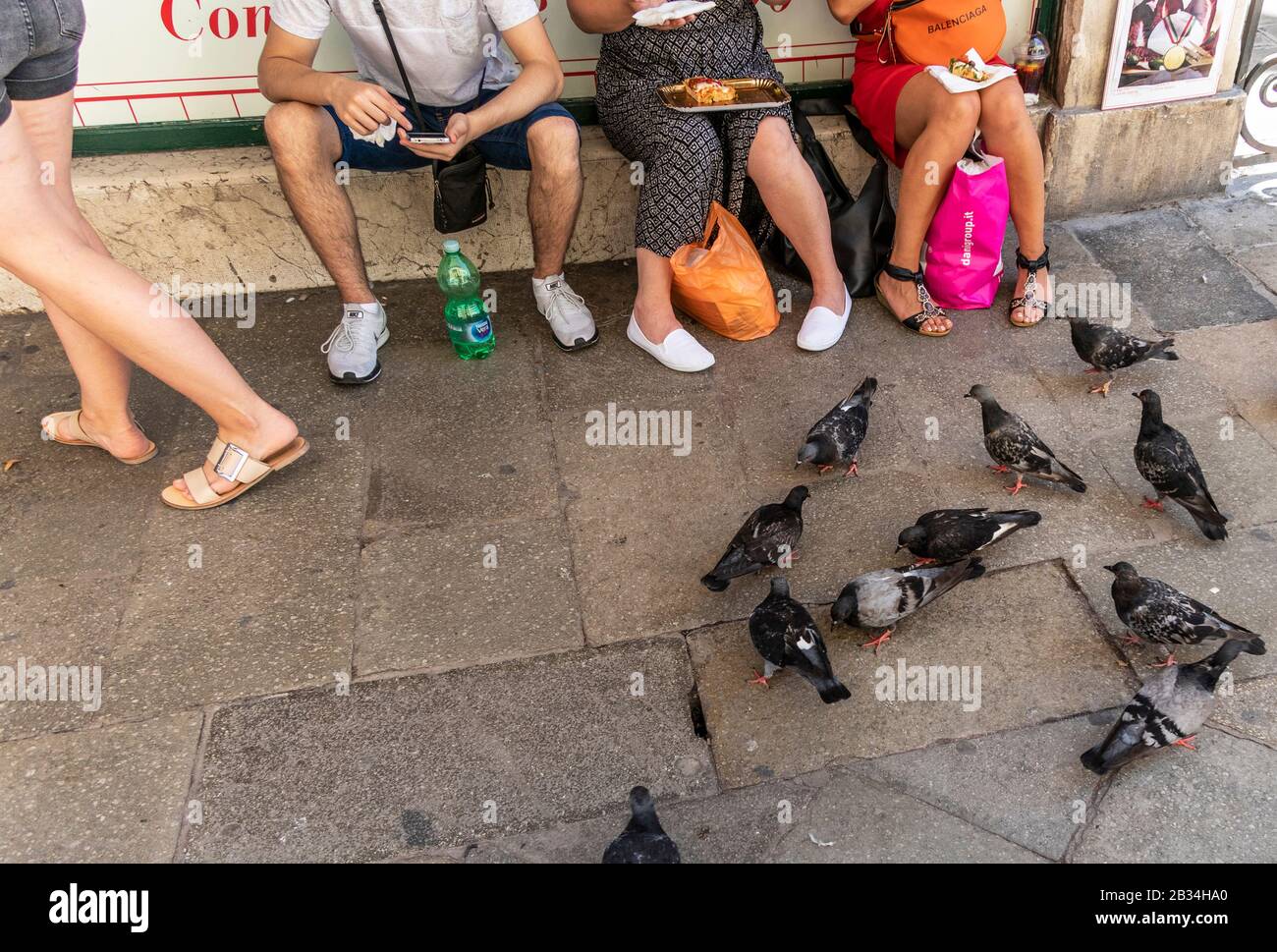 Tourist eating take away,fast foods on the streets of Venice, Italy Stock Photo