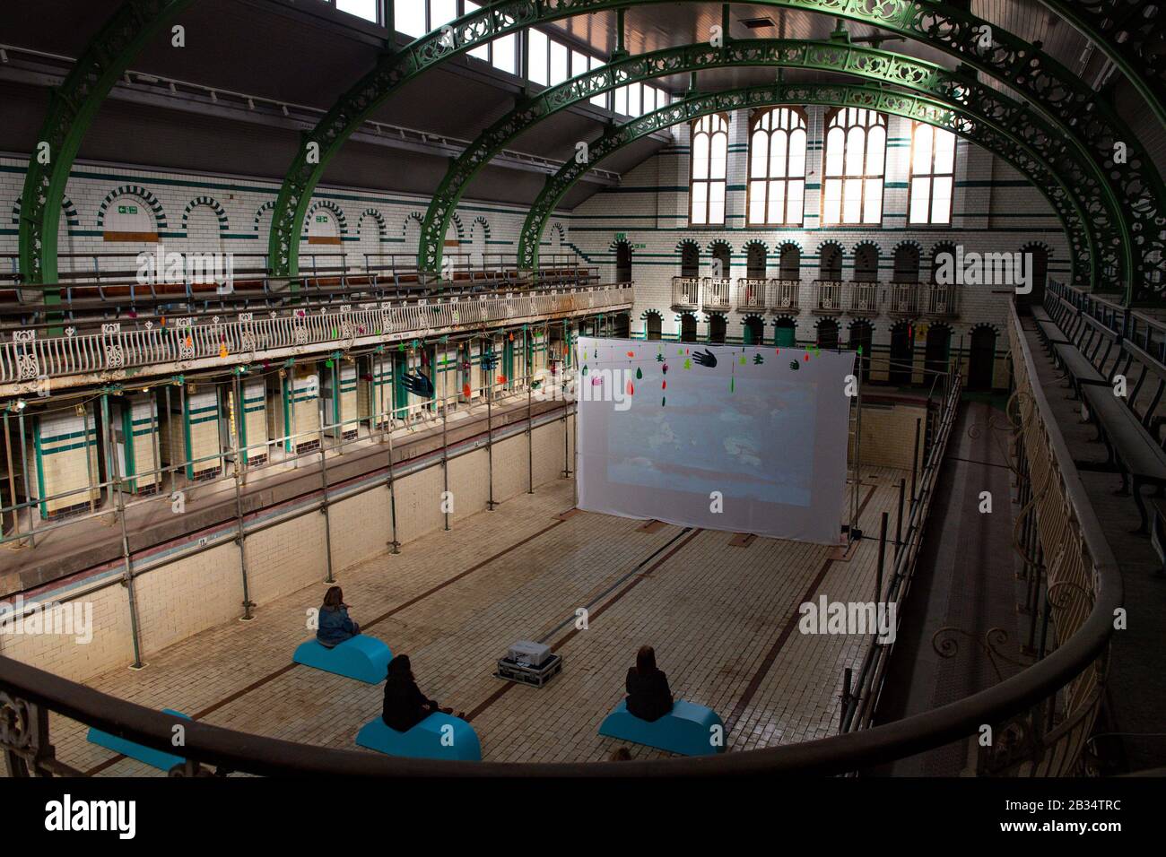 Members of the public view Specular Reflecular art installation at Moseley Road Baths, Birmingham, which features hand-painted animations created by 500 local people in conjunction with the National Trust. Stock Photo