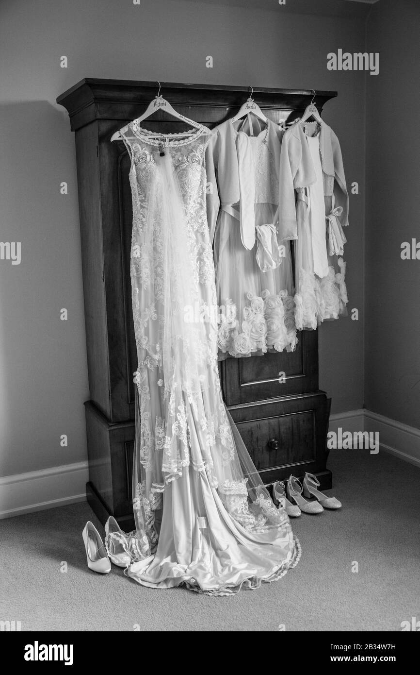 wedding dress and bridesmaids dresses hanging up waiting to be worn on ...