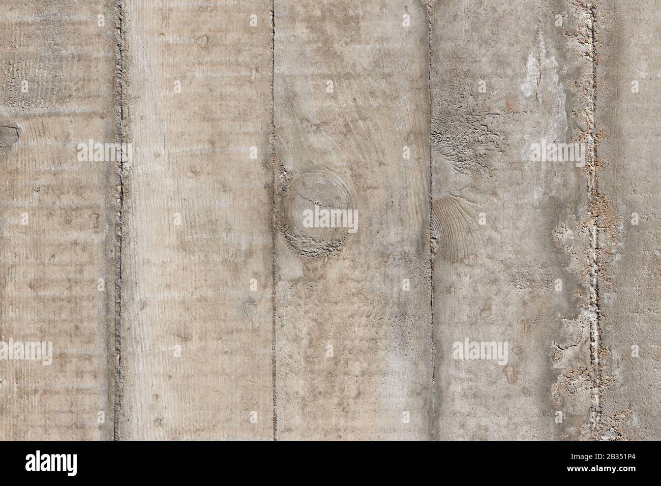 Concrete-Wood-Imprint-Background: background detailed texture of a rough grey-brown concrete wall, showing imprints of  wood  planks Stock Photo