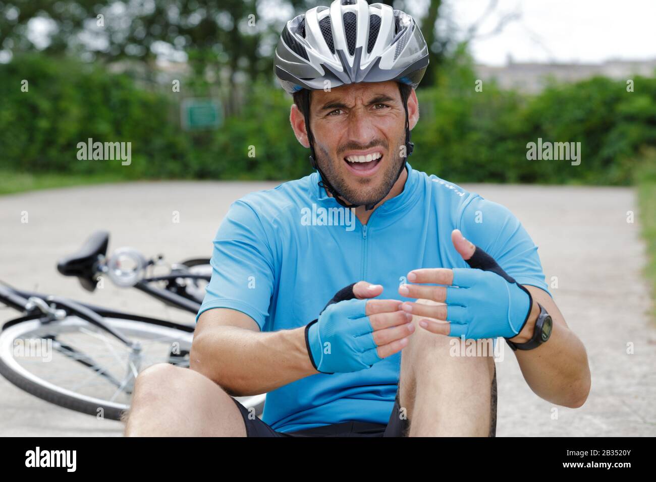 adult male nursing sore knee after falling from bicycle Stock Photo Alamy