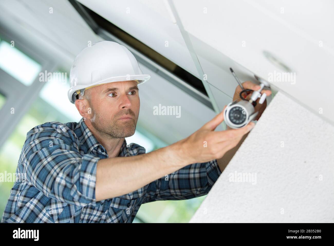 contractor fitting surveillance camera inside building Stock Photo Alamy
