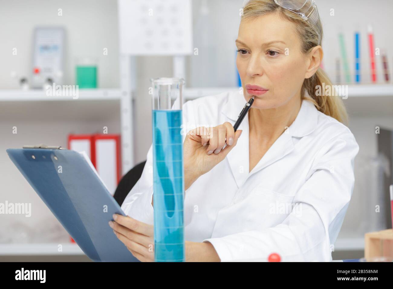 mature female lab worker holding a test tube Stock Photo - Alamy
