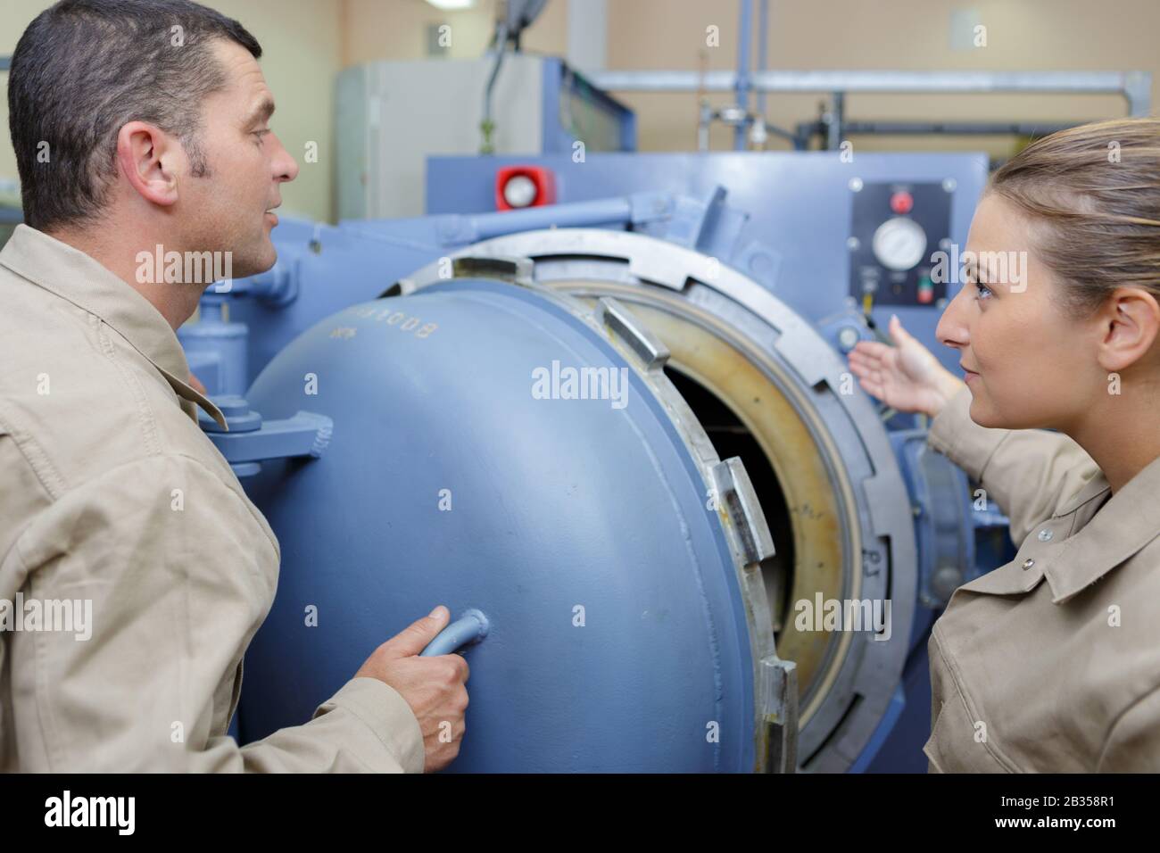 workers handling equipment for lifting industrial boilers Stock Photo
