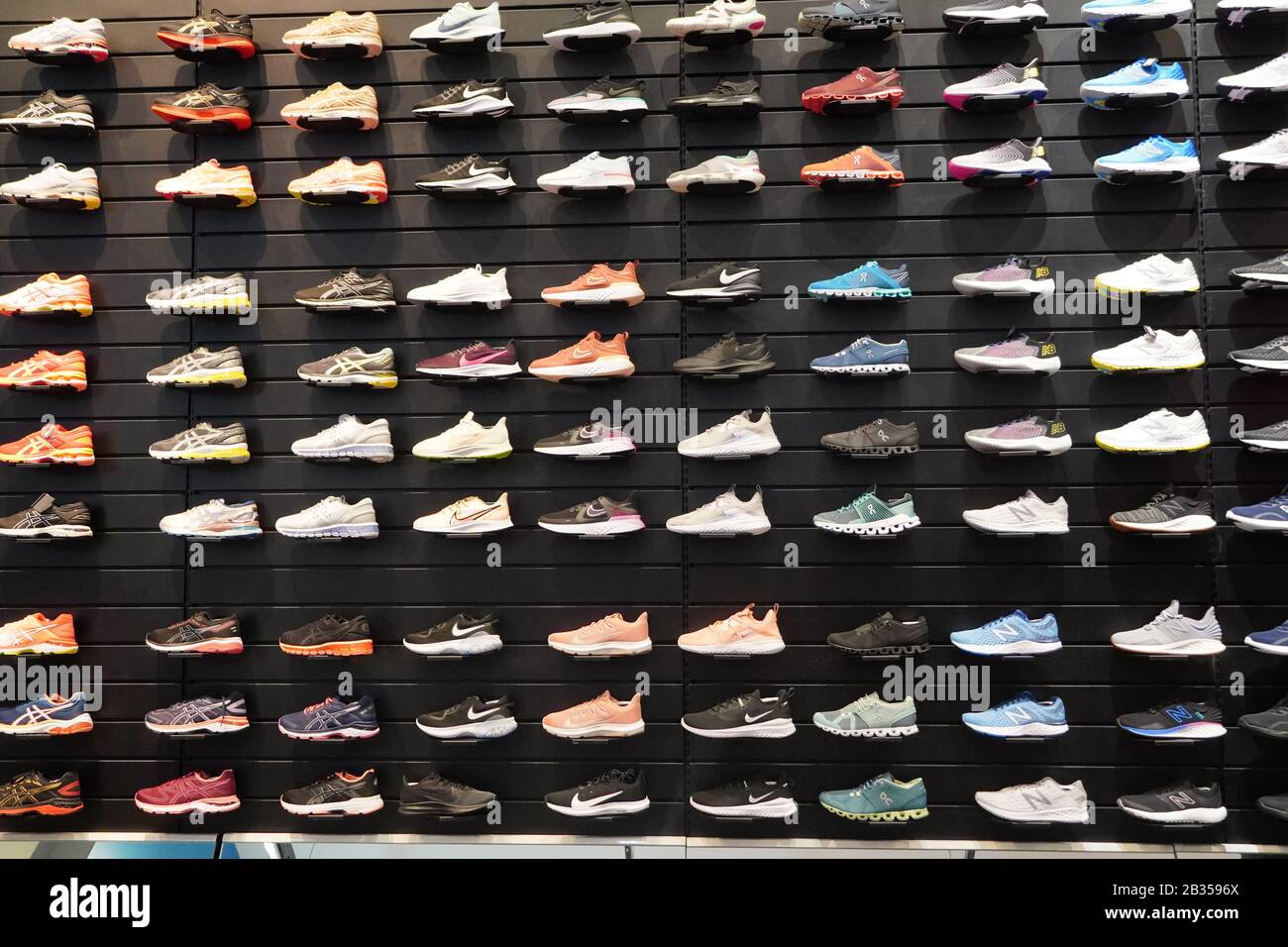 Shop display of a lot of Sports shoes on a wall. A view of a wall of ...