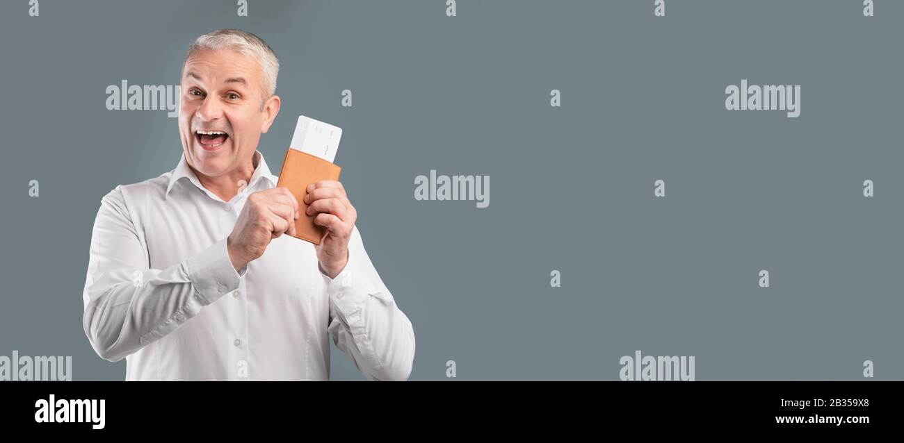 Excited senior man holding tickets and passport Stock Photo