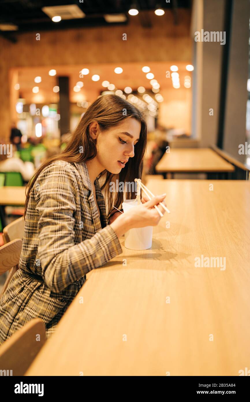 portrait of Real Young pretty woman, eating chinese food with chopsticks Stock Photo