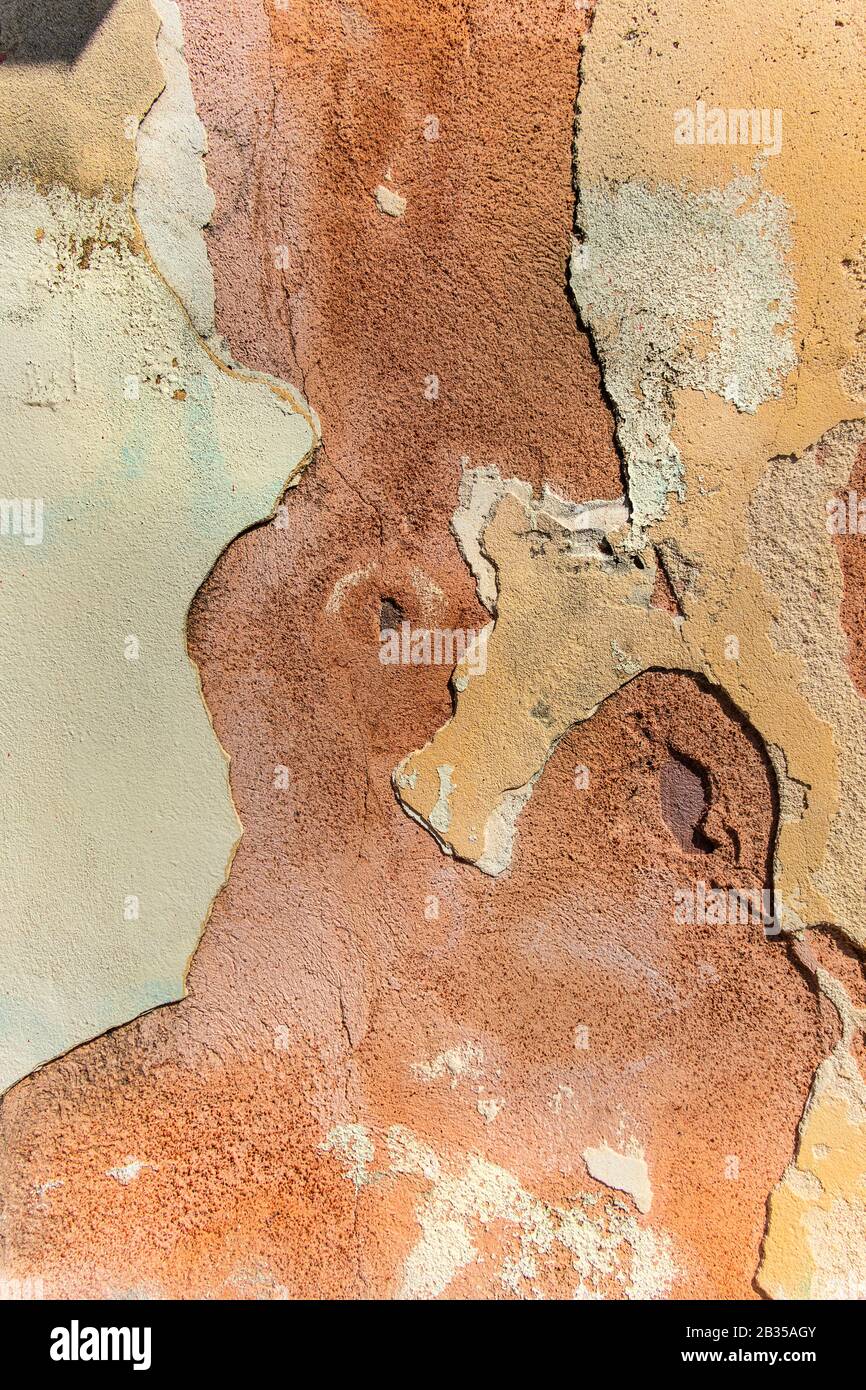 close up detail of colourful orange and terracotta peeling wall, Italy Stock Photo