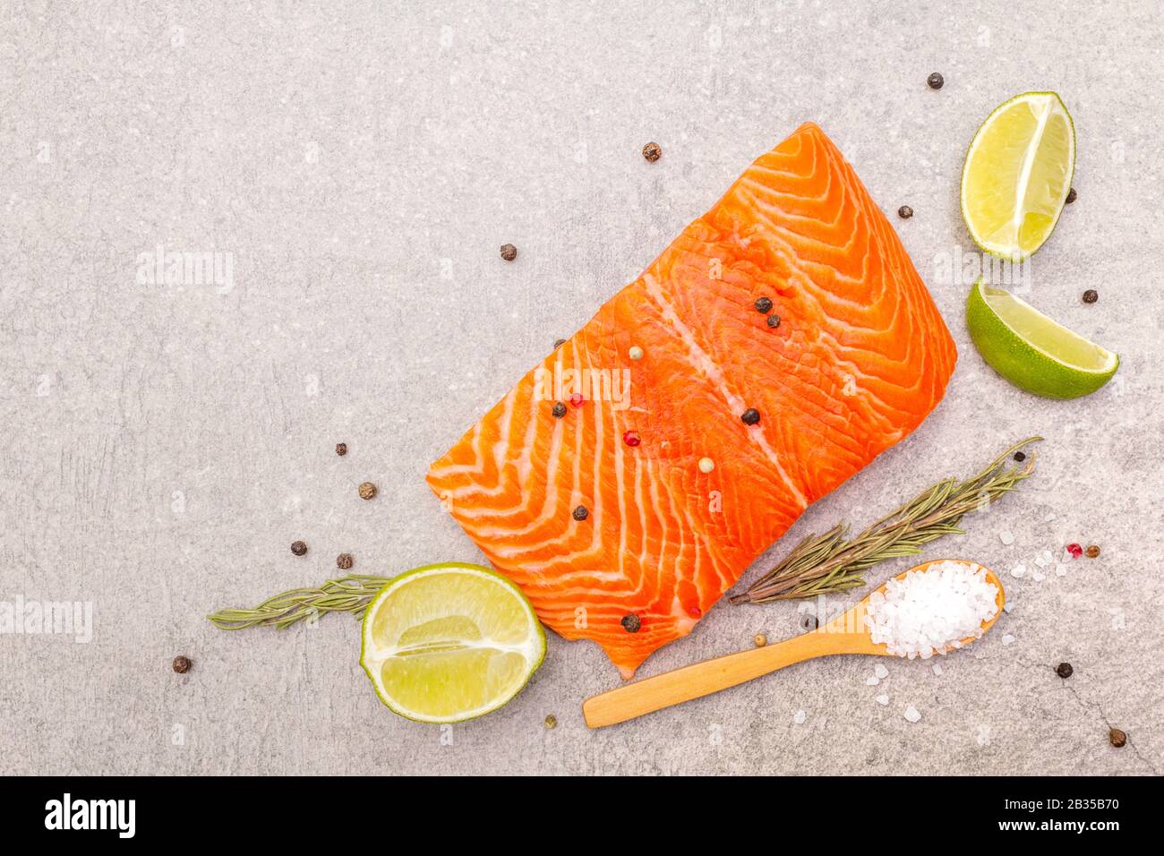 Raw trout (salmon) fillet piece with lime, rosemary, sea salt and