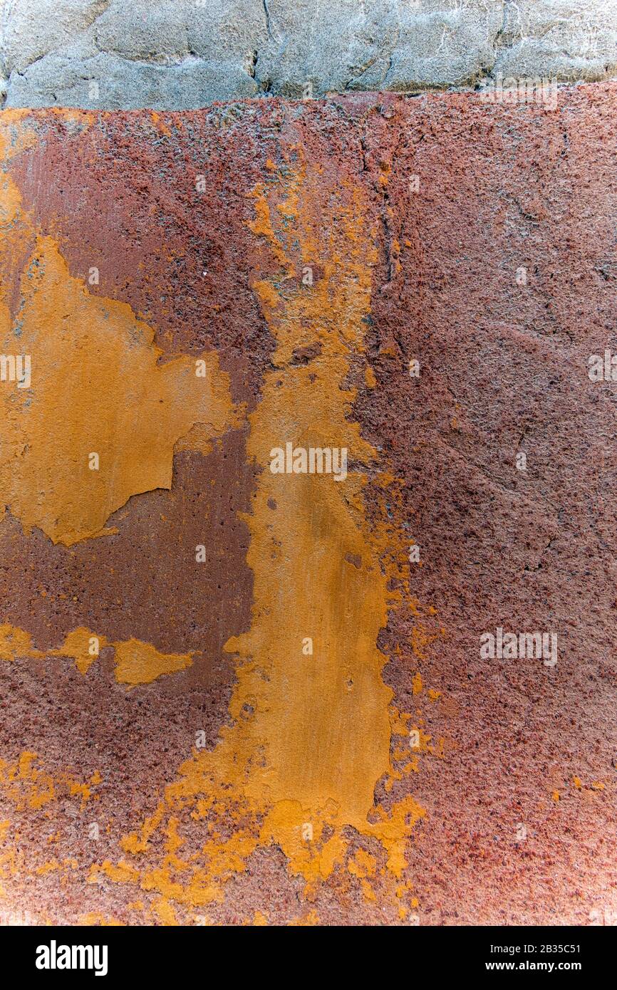 close up detail of colourful orange and terracotta peeling wall, Italy Stock Photo