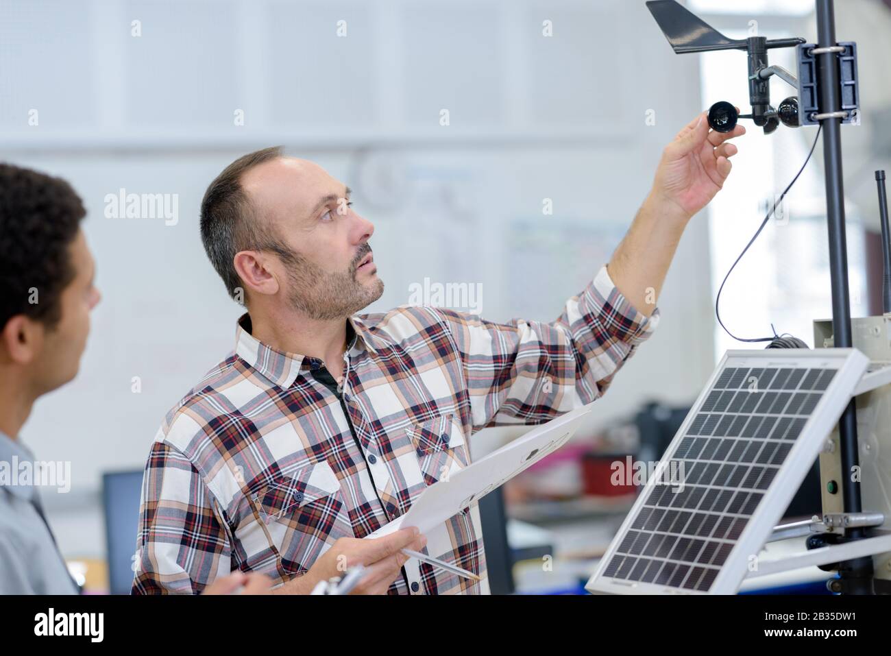 two engineer or installer inspecting solar energy panels Stock Photo