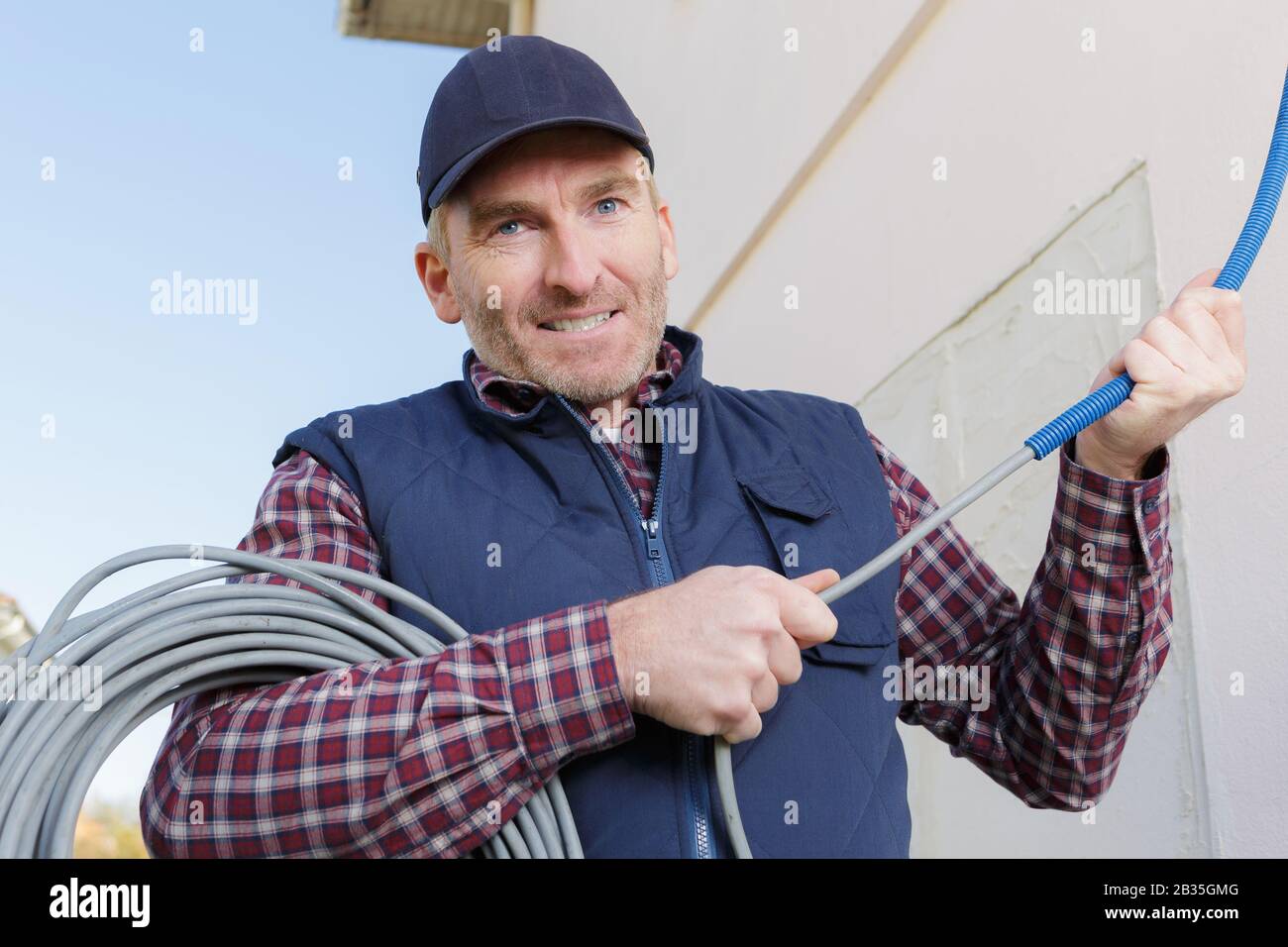 happy construction worker holding pipes Stock Photo - Alamy