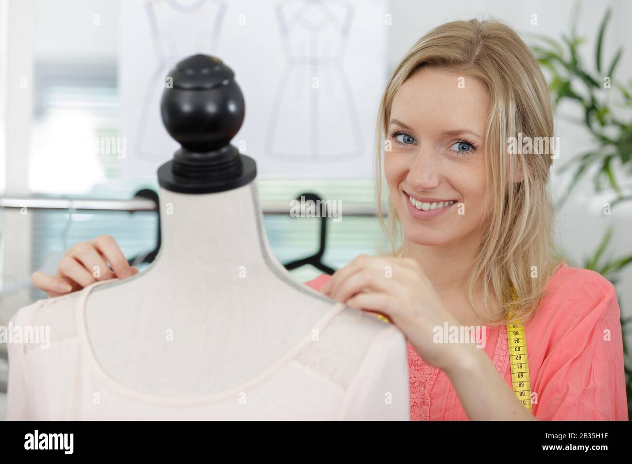 portrait of dressmaker stood next to mannequin Stock Photo Alamy