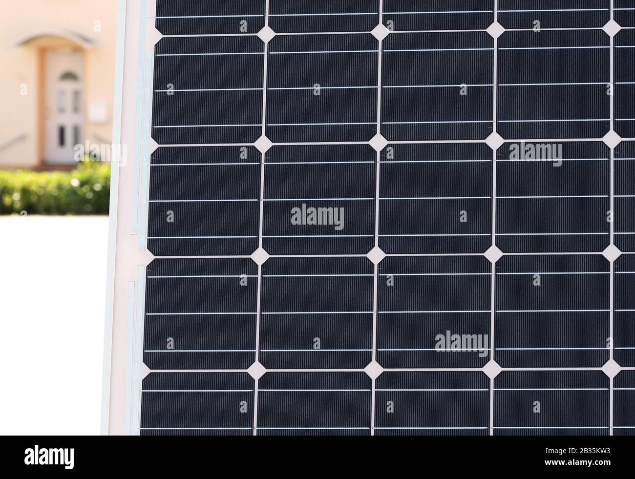 Solar module: solar module with monocrystalline cells with the entrance of an appartment house in the background Stock Photo