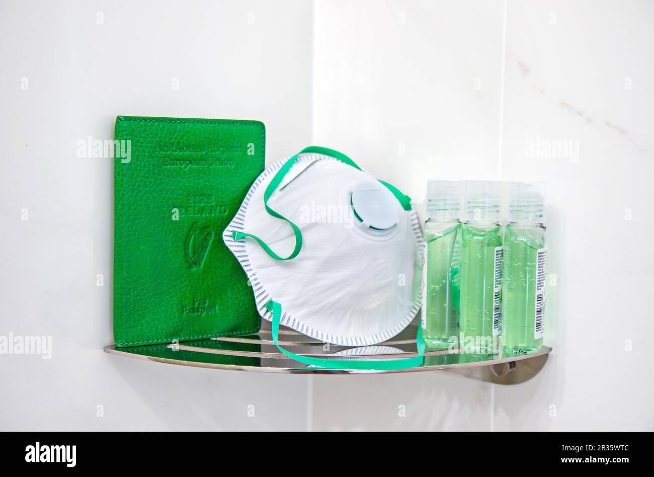 Green Irish passport cover on shelf beside face mask respirator and