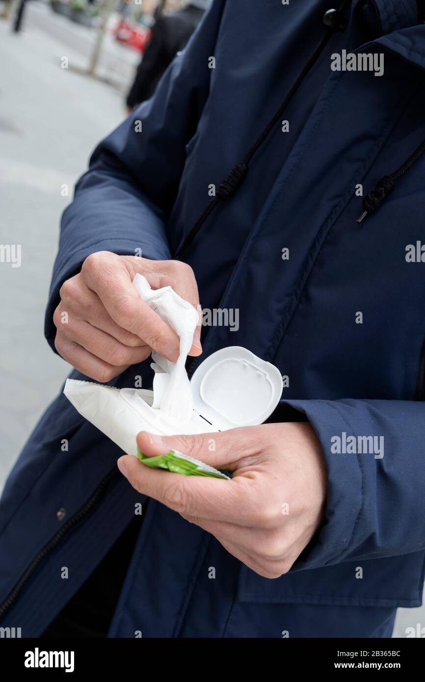 closeup of a caucasian man on the street about to disinfect his hands with a wet wipe Stock Photo