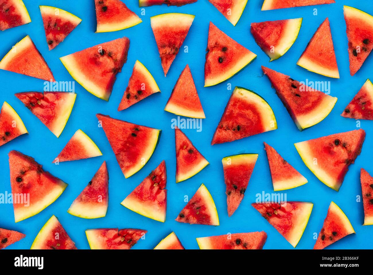 Sliced slices of watermelon on a blue canvas. Pieces of fresh watermelon as a background. Summer concept. Flat lay, top view Stock Photo