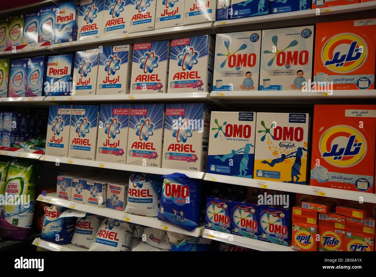 Supermarket display with different brands of washing powder in boxes. Wholesale. Tide, Ariel, Omo laundry detergent boxes lined up for sale in a store Stock Photo
