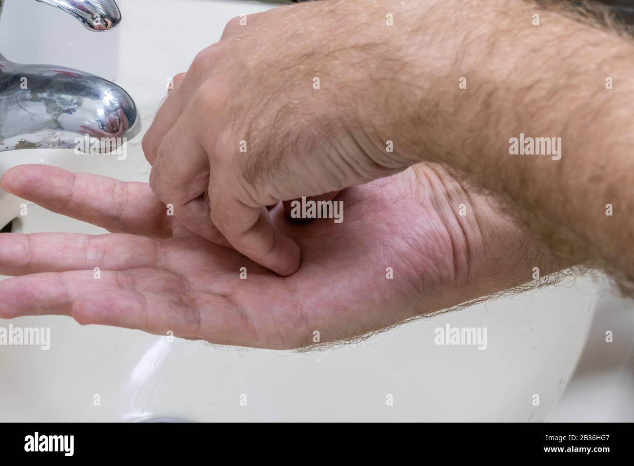 Man washing hands in basin close-up, one of several in handwashing steps series Stock Photo