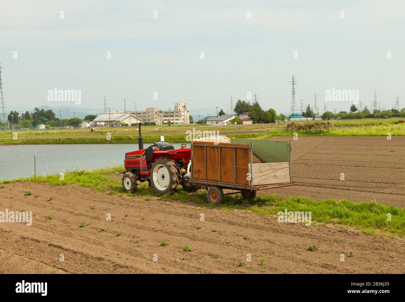 MARIOKA, JAPAN - MAY 22, 2017: Small red Japanese tractor (Yanmar F18d type) with cart on the field near Morioka city, Japan Stock Photo