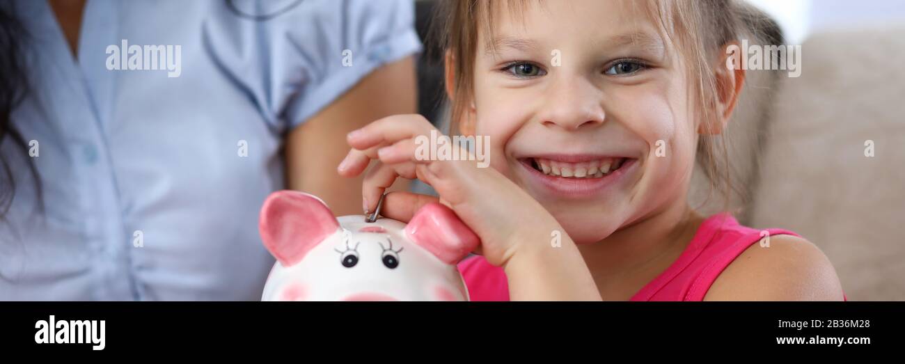 Child putting coin in thrift-box Stock Photo