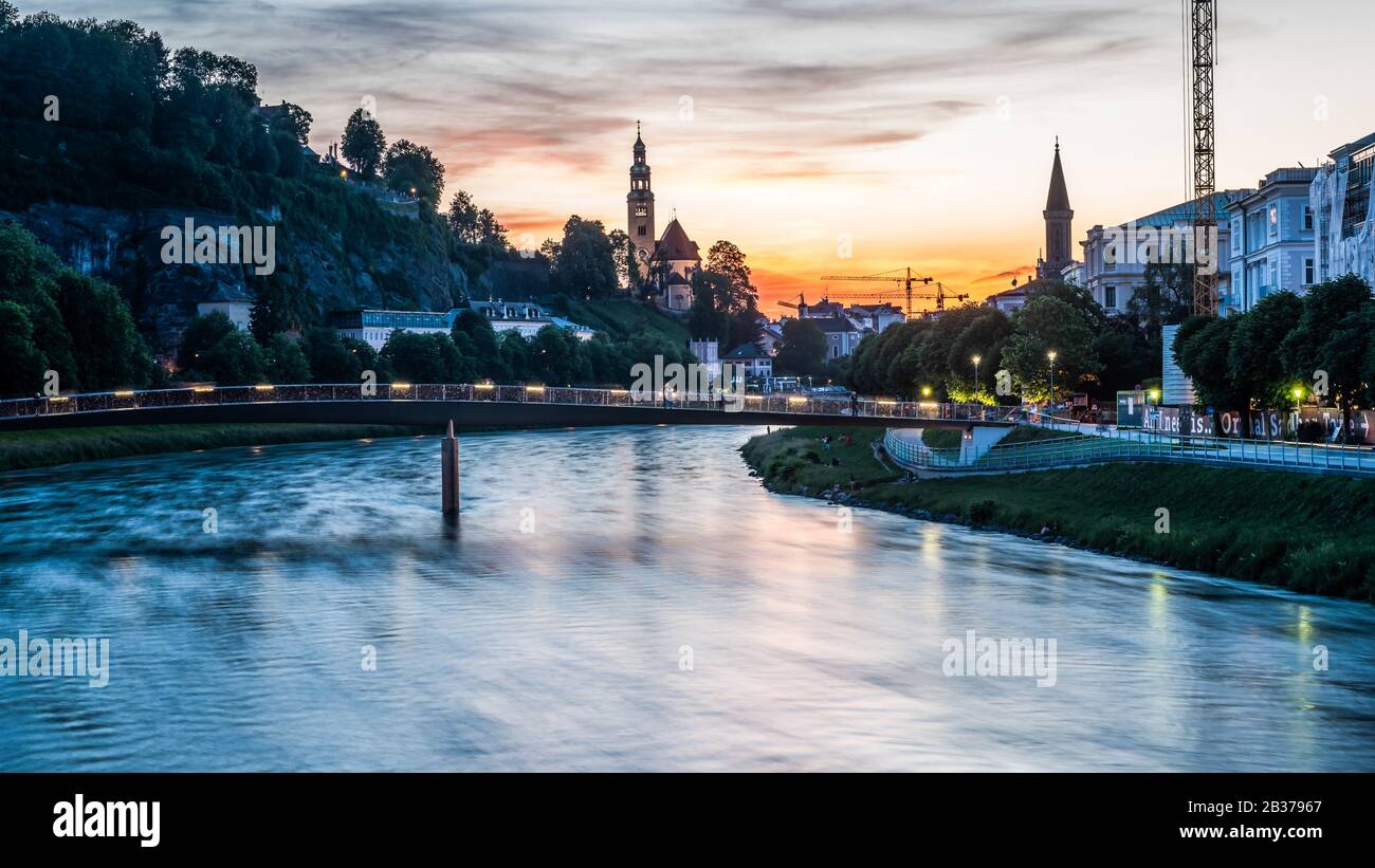 26-may,2018: People over bridge in the evening and on the bank of Salzac river in Salzburg,an Austrian city a birth place of famed composer Mozart Stock Photo