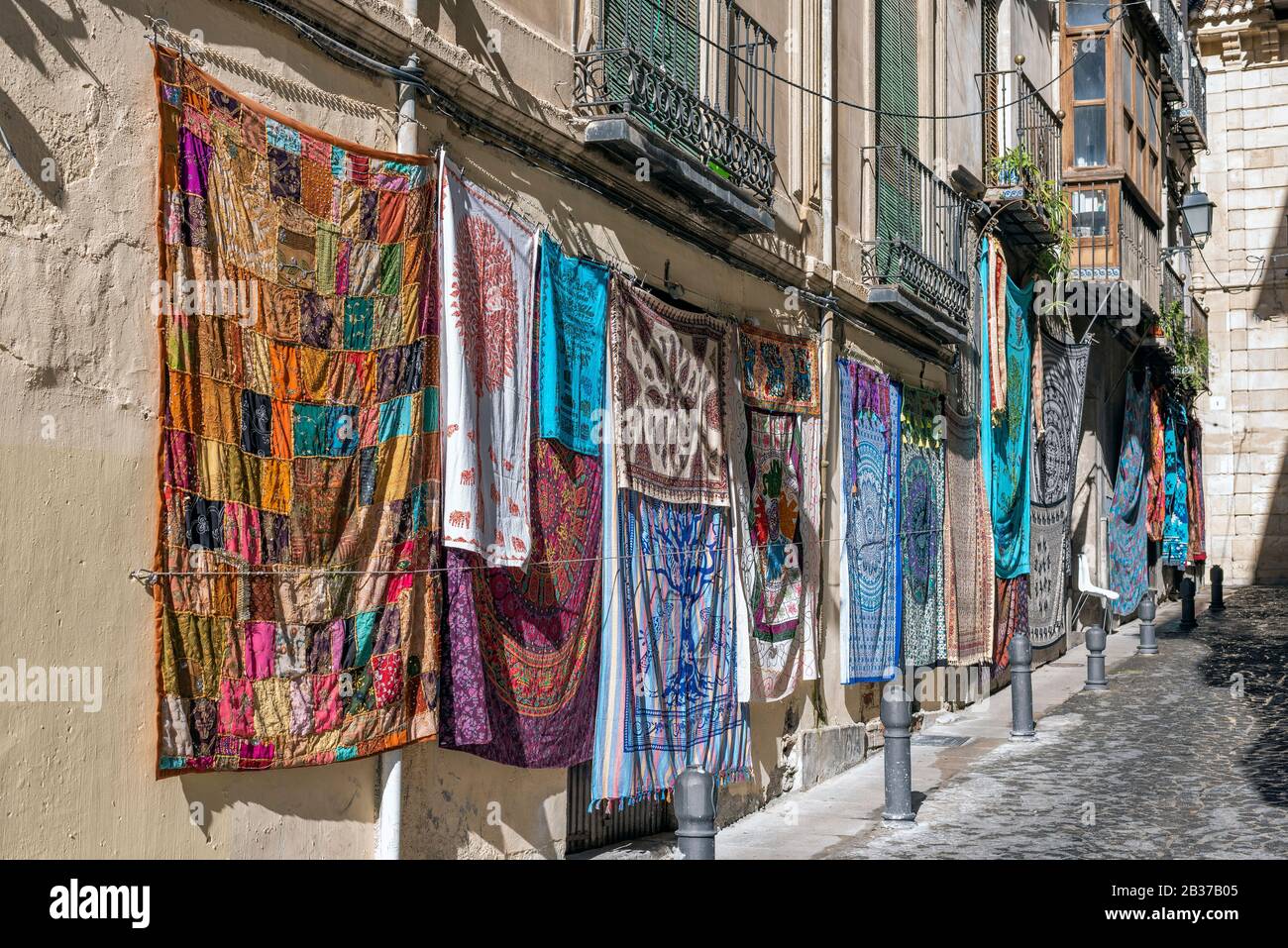 Rugs of various colors hanging on the wall in a street. Stock Photo