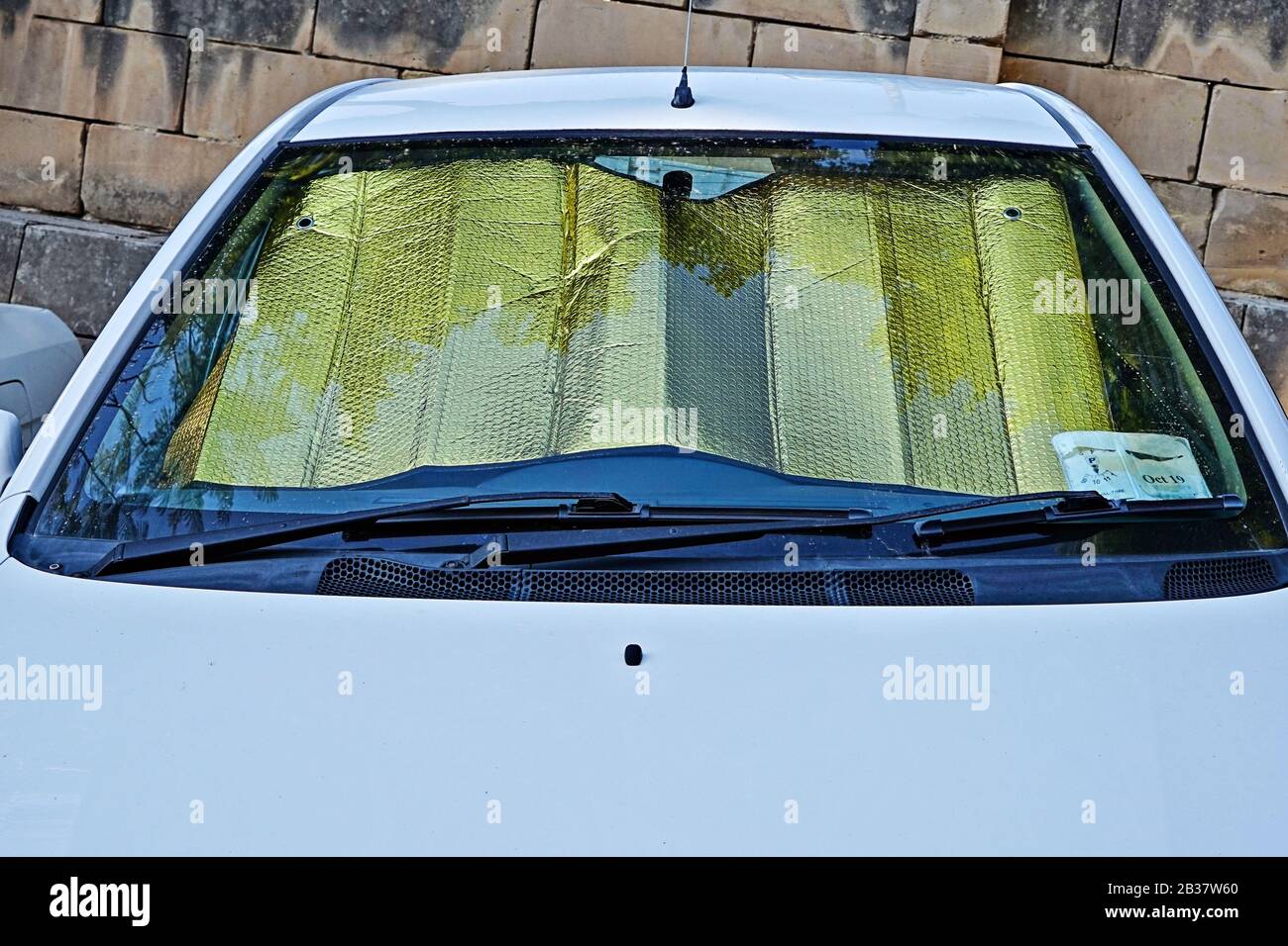 Windshield of car with protective reflective sunscreen surface inside
