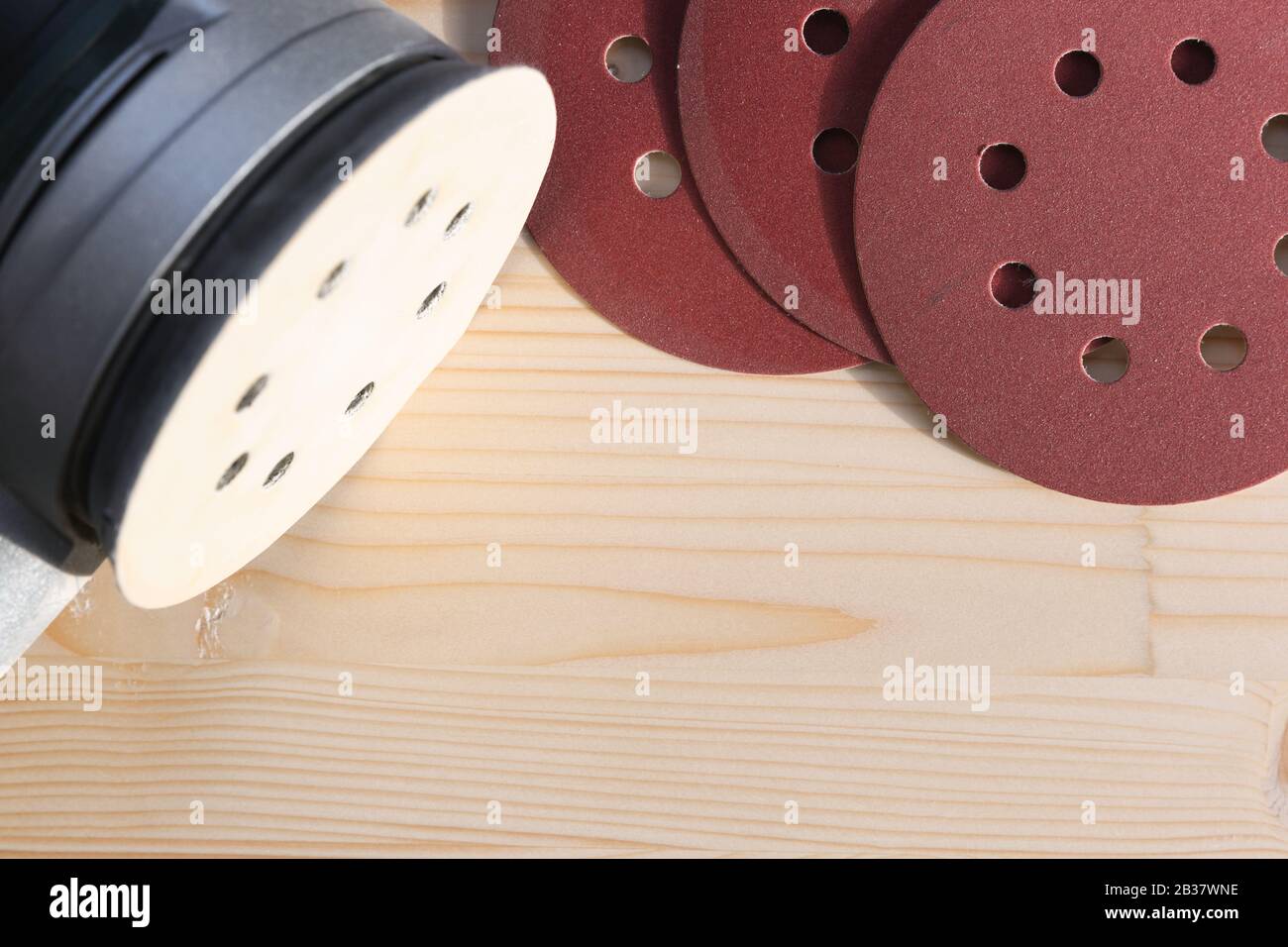 Carpentry. Wood sanding. Orbital sander for woodworking. In a natural light Stock Photo