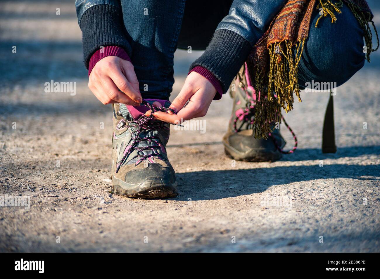 Schoelace Tying Shadow Art Trail Reference: Hiker Tying Shoelace On A Trail Path In The Evening