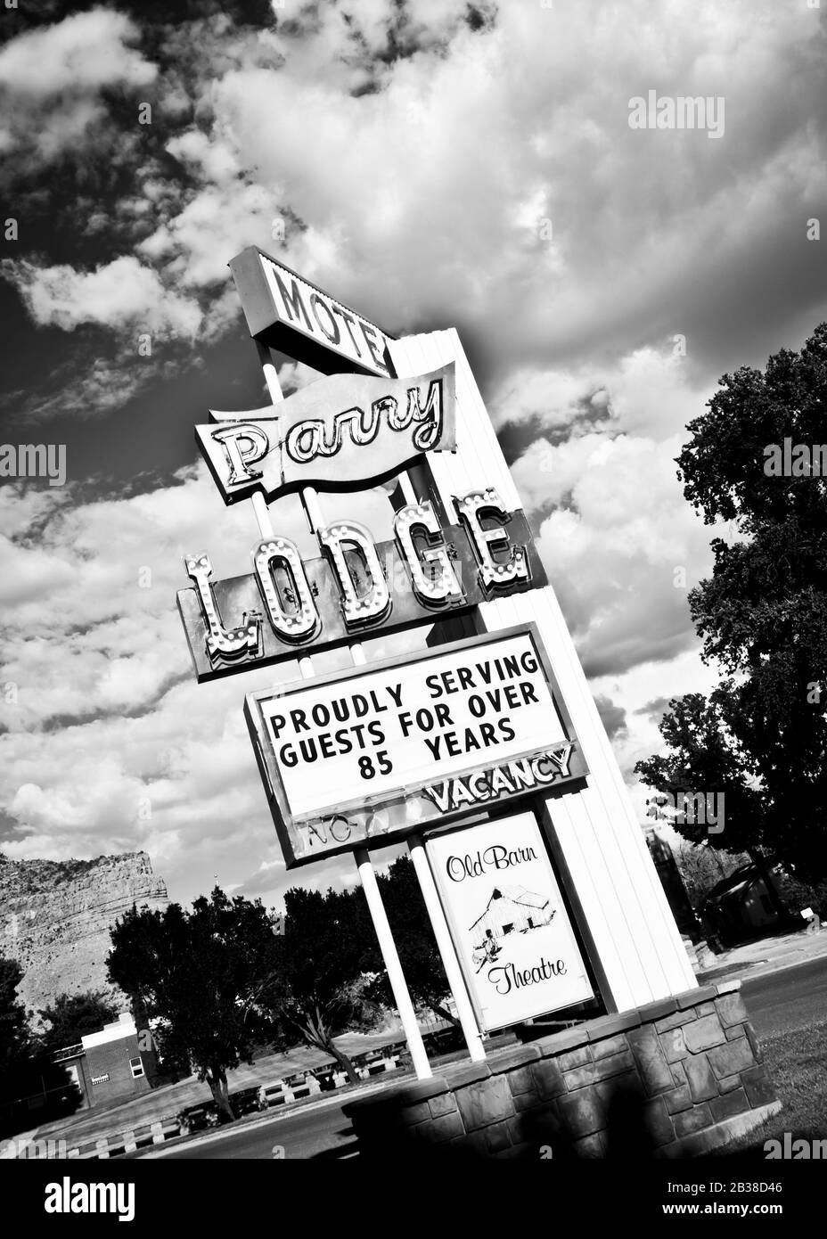 Black and white road side neon sign with dramatic clouds overhead Kanab Utah USA Stock Photo