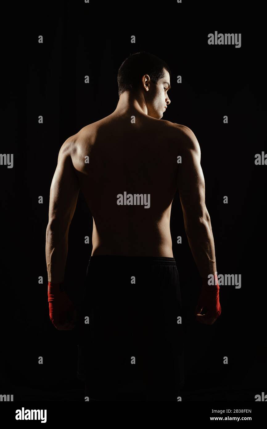Male boxer posing his powerful back against black background Stock Photo -  Alamy