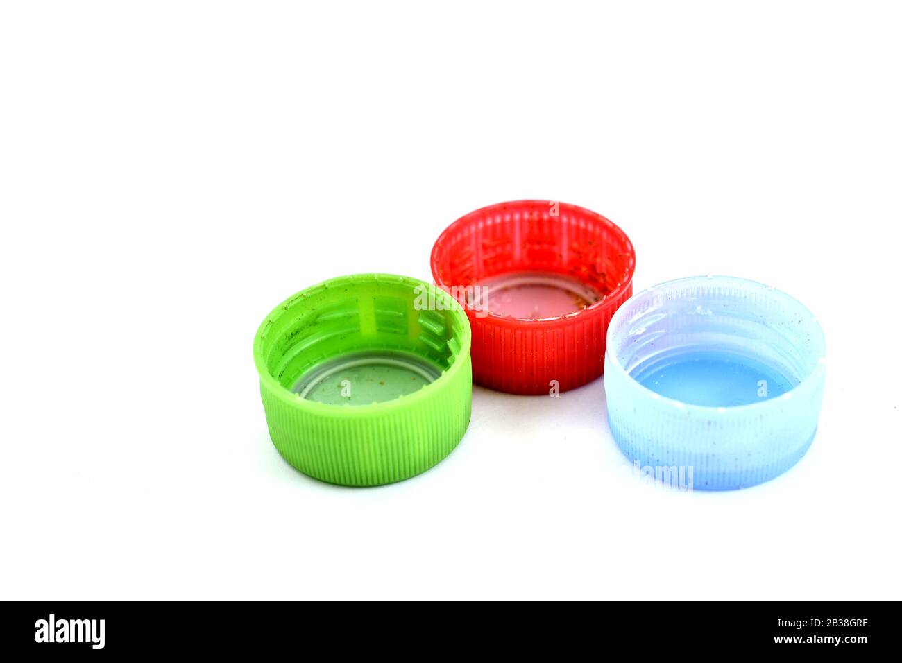 various dirty pet bottle caps on white background Stock Photo - Alamy