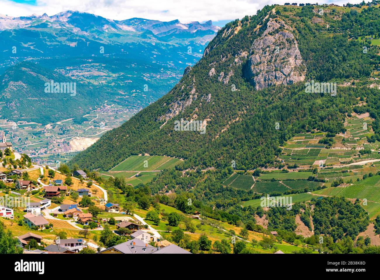 View of village in Alps in summer with green mountains Stock Photo - Alamy