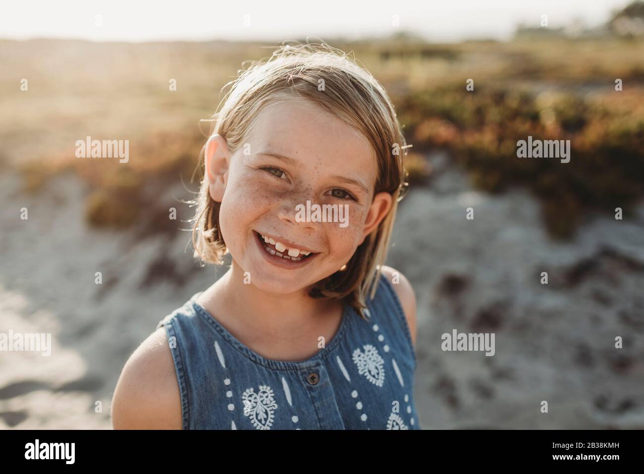 Portrait of young school age girl with freckles smiling on beach Stock Photo