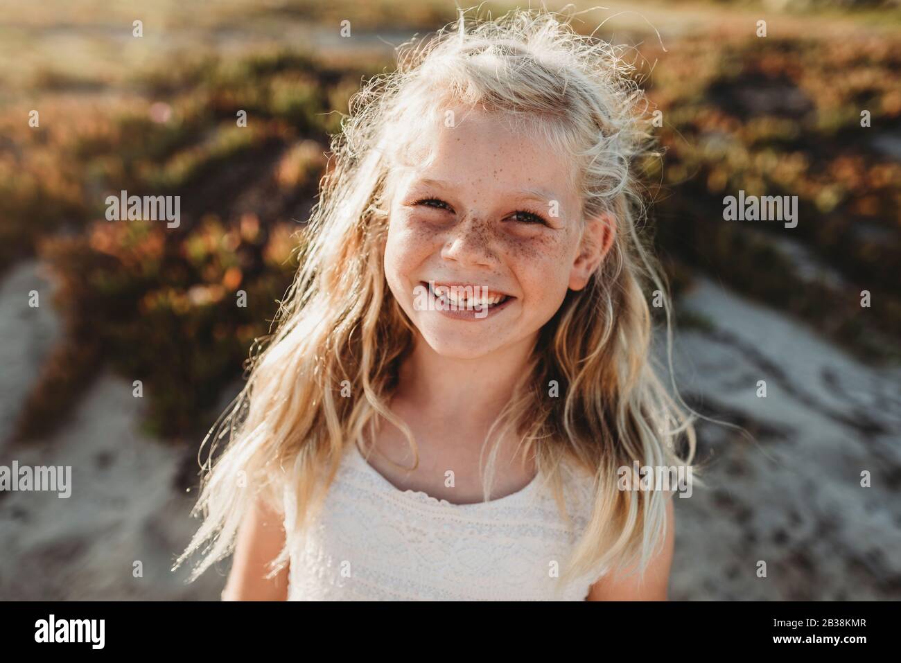 Portrait of young school age girl with freckles smiling at camera Stock Photo