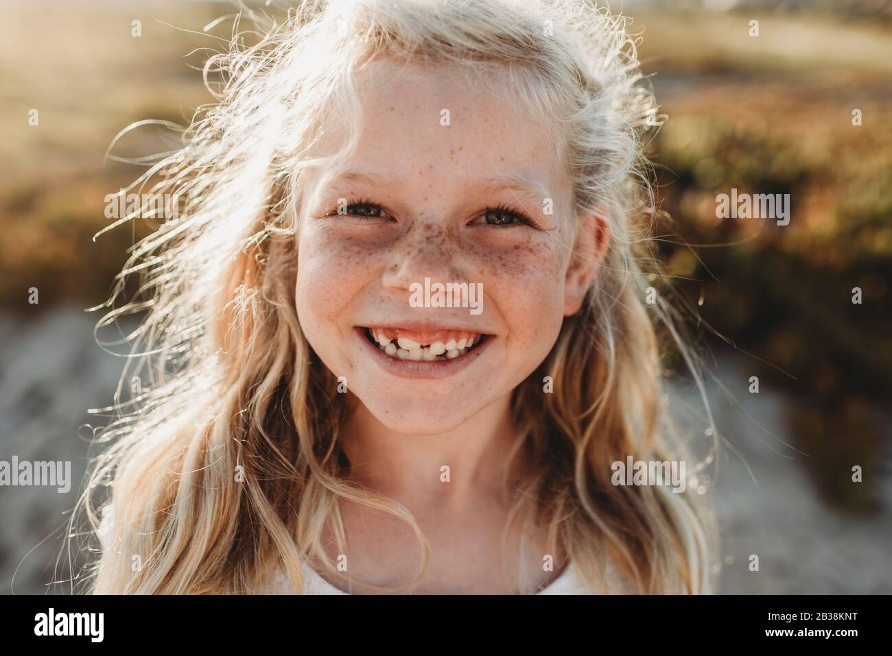 Close up Portrait of young school age girl with freckles smiling Stock Photo