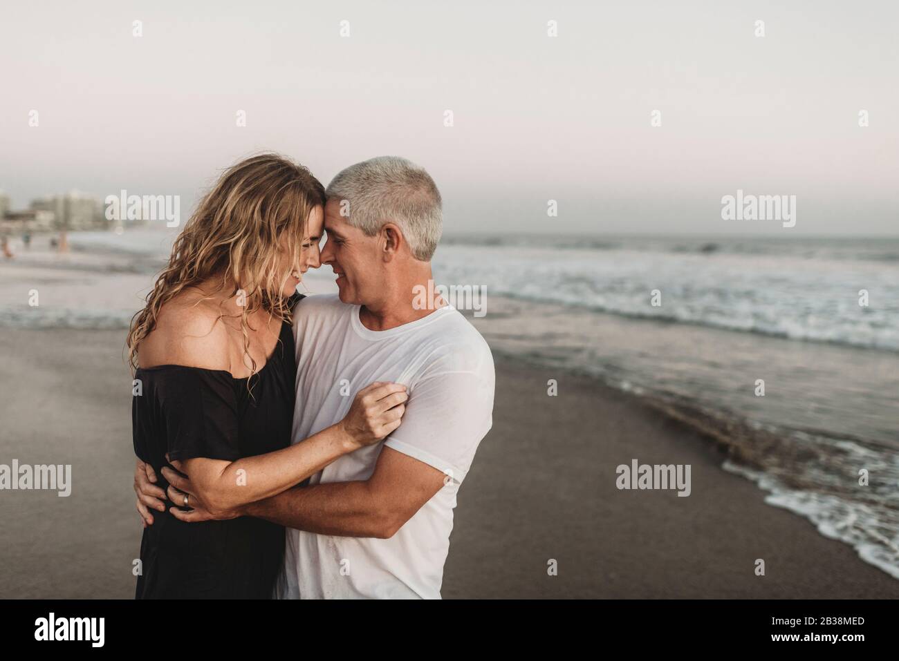 Side view of married couple embracing each other in ocean Stock Photo