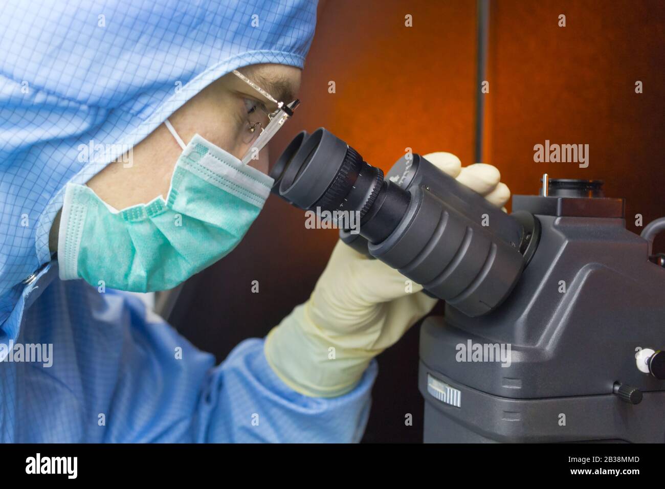 The inspector making check on microscope in clear room Stock