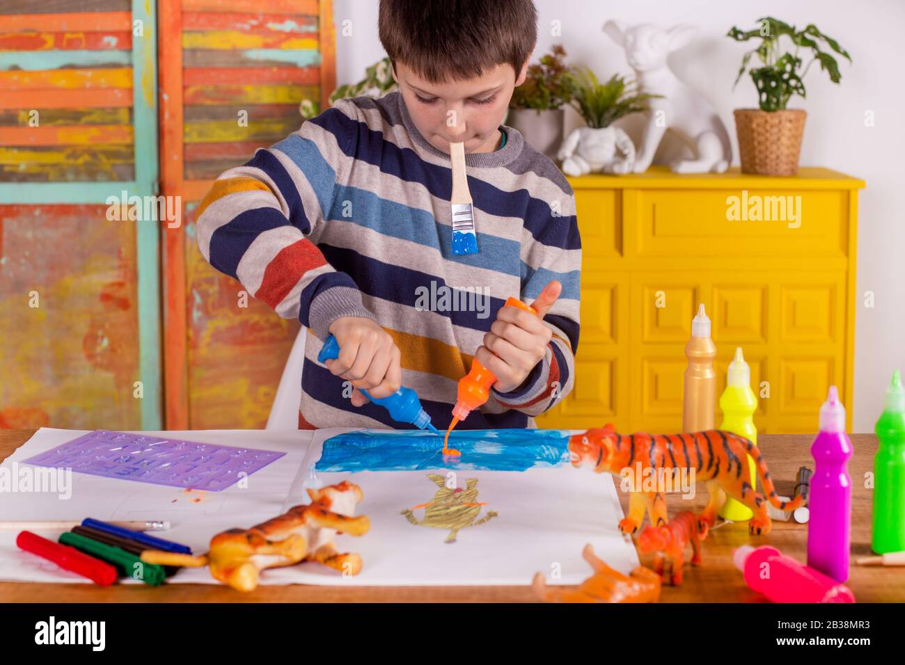 Boy creating artwork at home. Stock Photo