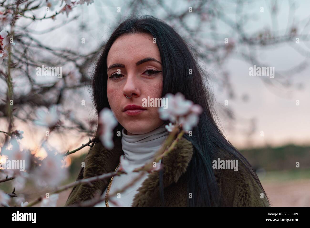 Retrato de mujer con flores y fondo atardeciendo Stock Photo