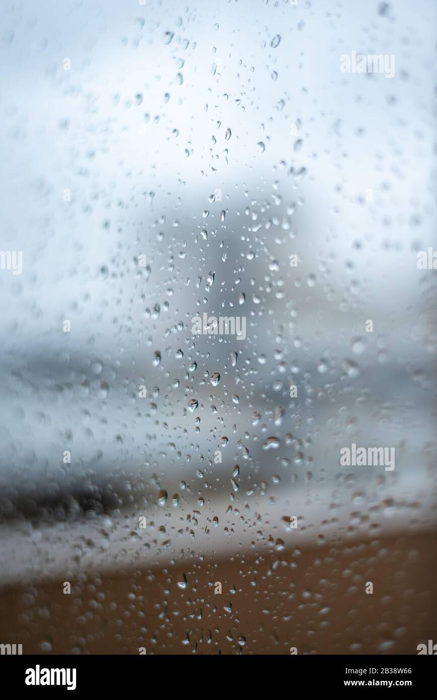 Window on a rainy day with small drops in it. Focus on the small raindrops Stock Photo