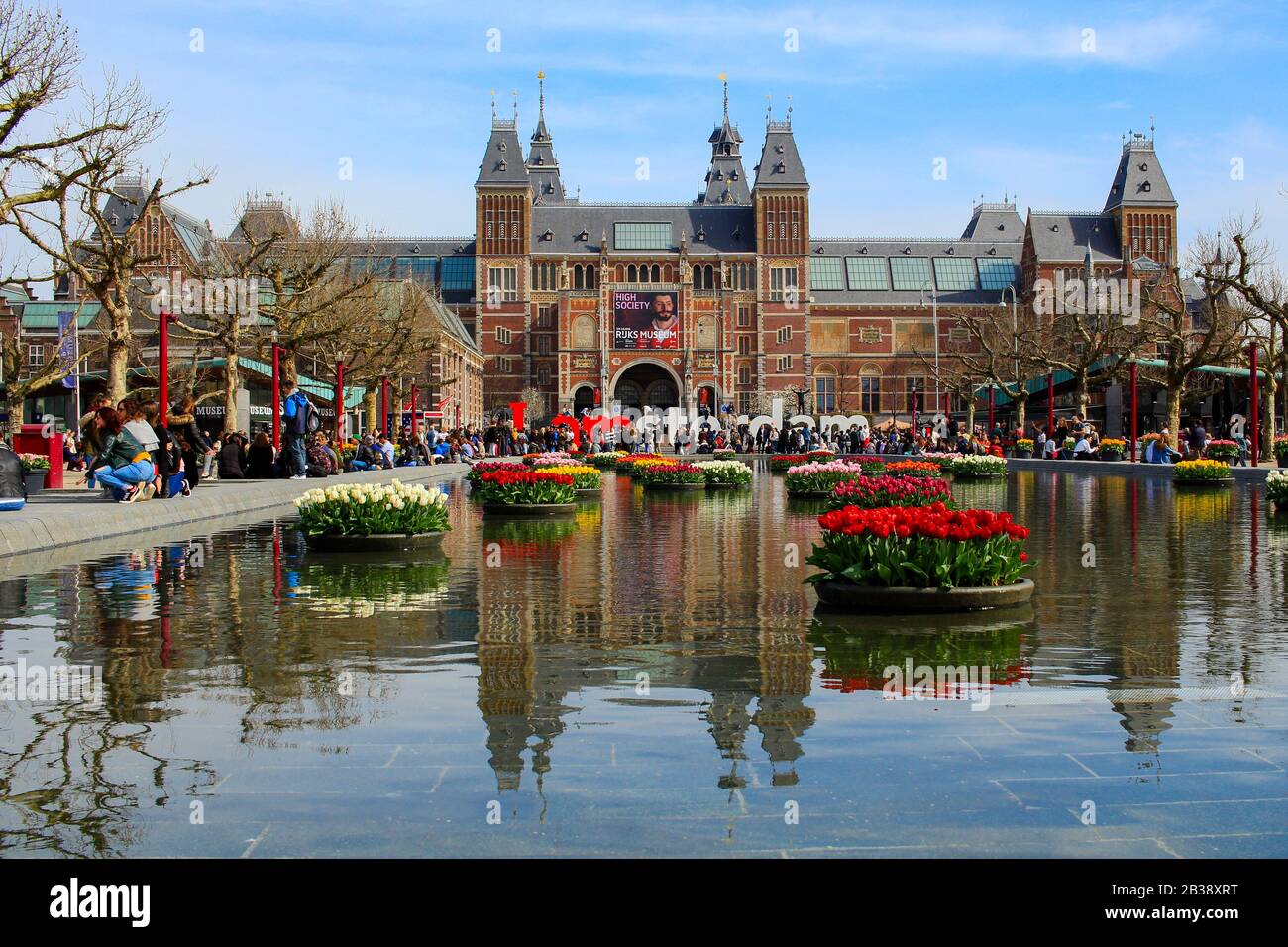 AMSTERDAM, NETHERLANDS - APRIL 22 2017: Rijksmuseum National Museum with I Amsterdam sign and tulips in the reflecting pool. Amsterdam, Netherlands Stock Photo