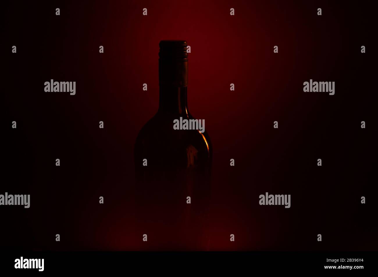 Studio shot of isolated dark black blurred red wine bottle silhouette (focus on bottle neck) Stock Photo
