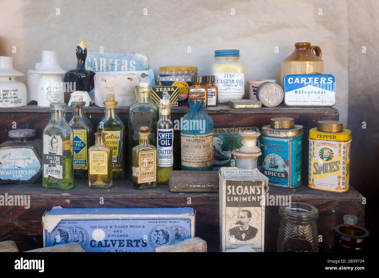 An historic collection of old bottled goods and kitchen accessories as once displayed in a now closed village shop operating in the 1940s and 1950s Stock Photo