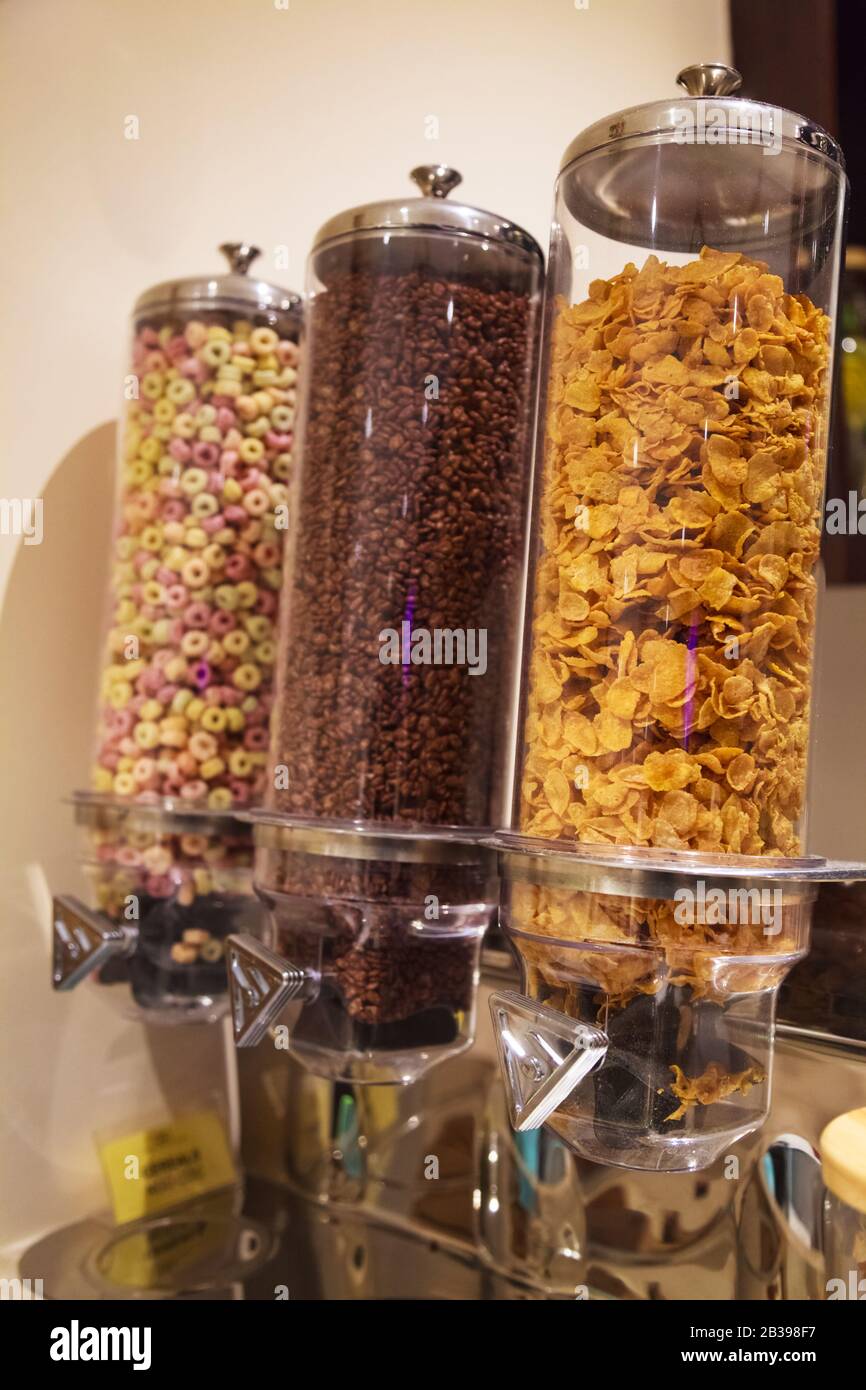 Selective Focused Variety of Breakfast Cereals Morning Meal; Crisp Dark Chocolate, Corn Flakes and Fruit Loops in Cereal Glass Jar Dispensers. Nutriti Stock Photo