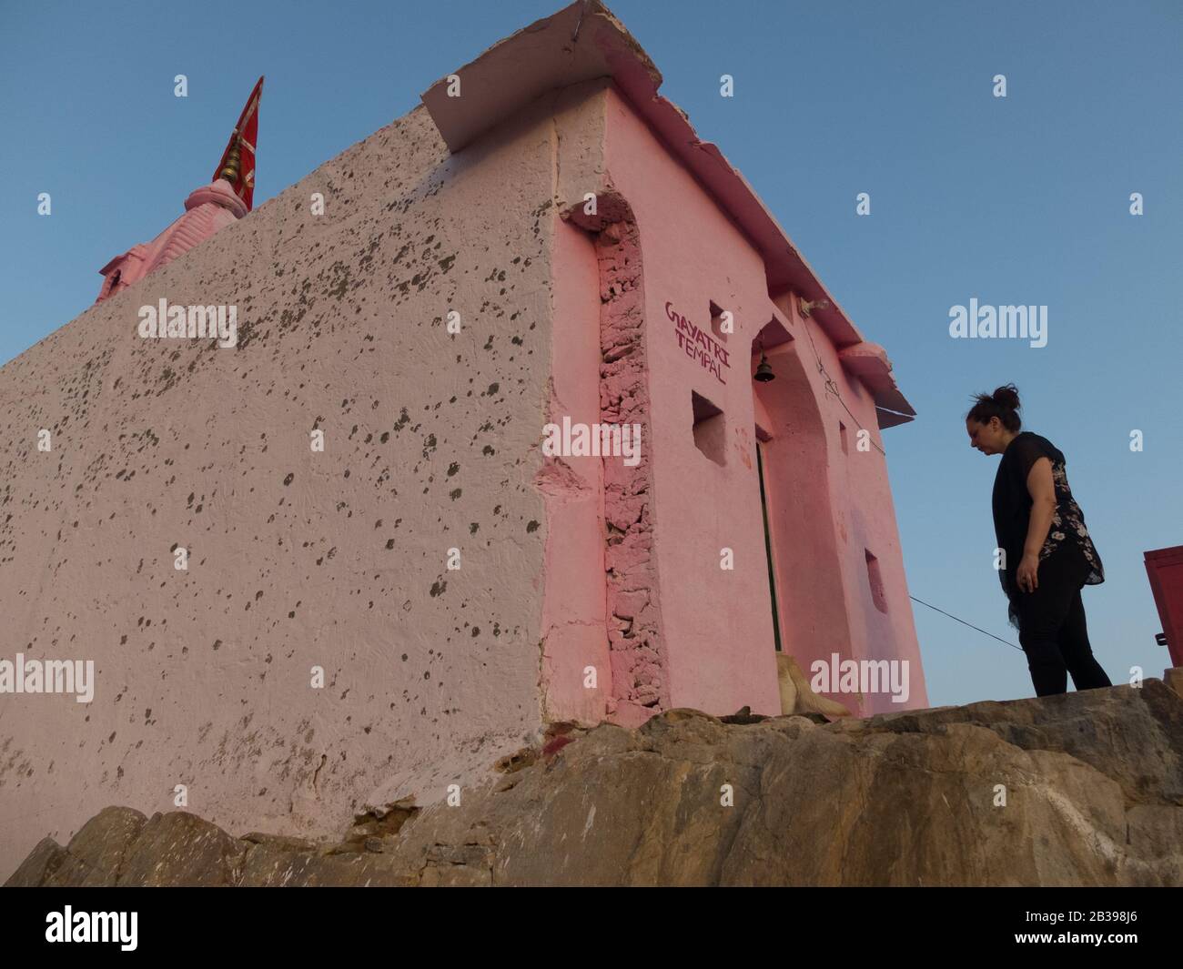 A female western traveller stands outside Gayatri hilltop temple about to walk inside. Stock Photo