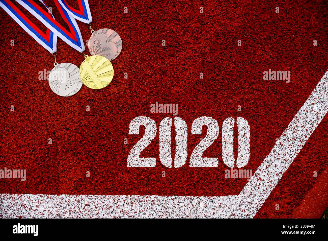 Medal set and Tittle 2020 on red sport running, athletics track Stock Photo